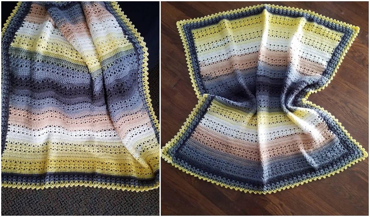 Handmade baby blanket featuring a crochet pattern with stripes in shades of gray, pink, beige, and yellow. Complete with elegant shell edging, it is beautifully displayed draped and flat on a wooden floor.