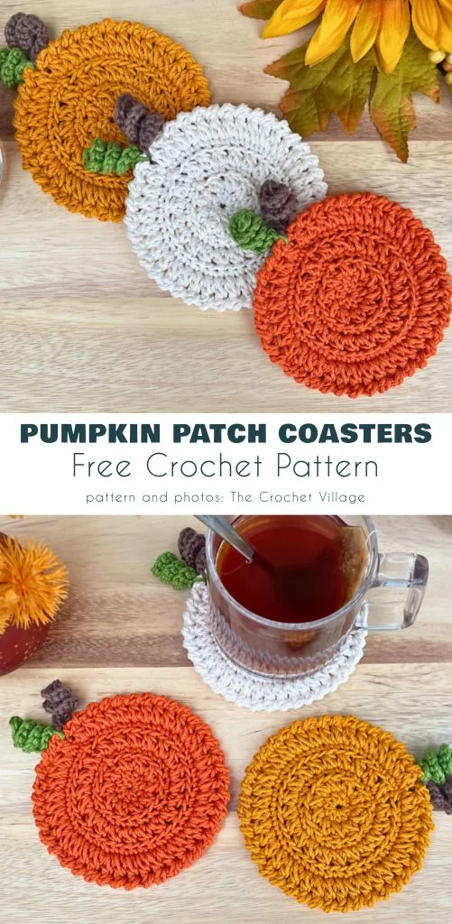 Three crocheted coasters shaped like pumpkins in orange, white, and yellow are displayed on a wooden surface; a glass teacup sits on one coasterโa charming autumn accent you might find featured by magazine@yourcrochet.com.