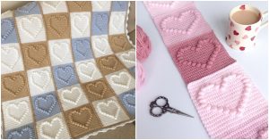 Two beautifully crocheted blankets: one with brown, blue, and white heart patterns that resemble popcorn stitches, and a second featuring pink and white heart designs. A pair of scissors and a mug are nearby.