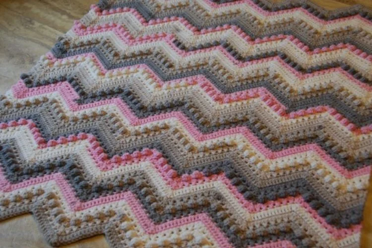 A chevron afghan with pink and grey zig zags.