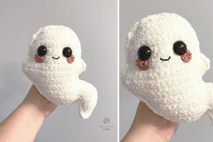 A hand holding a crocheted ghost stuffed animal.