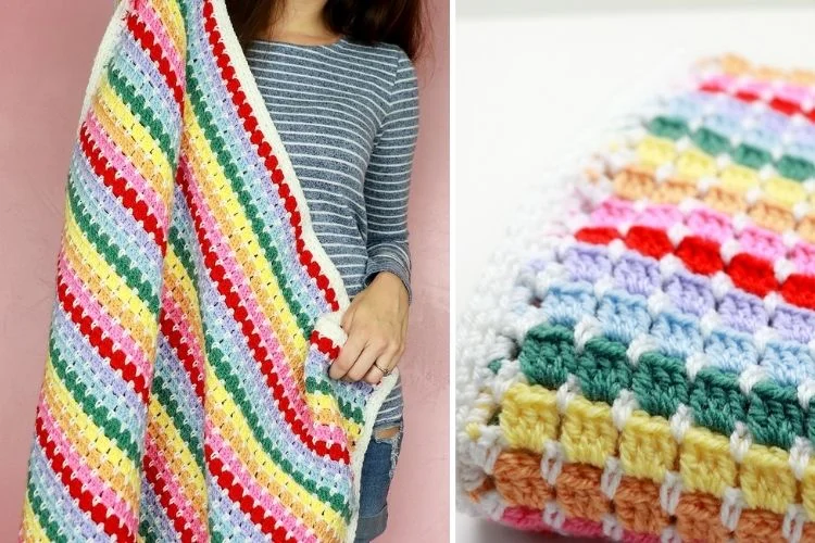 A woman is holding a rainbow crocheted afghan.