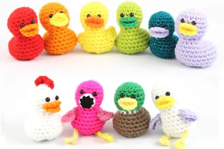 A group of crocheted ducks in different colors.