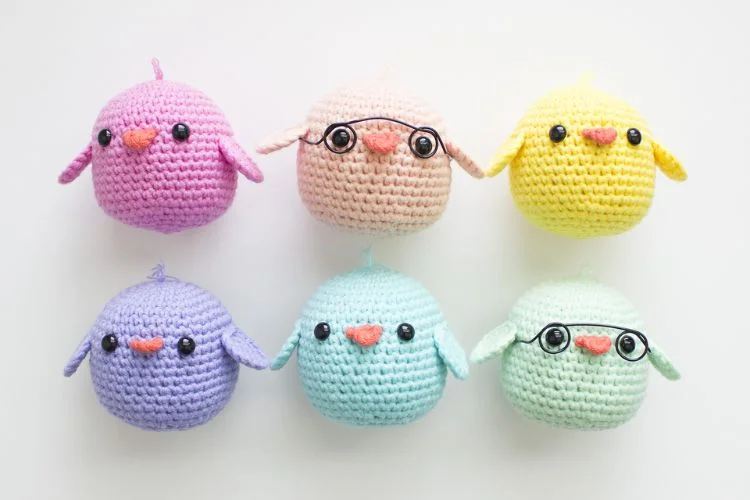 A group of crocheted birds in different colors.