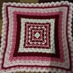 a crochet square blanket worked with shell stitches