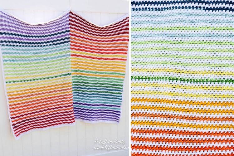 A rainbow striped afghan hanging on a white wall.