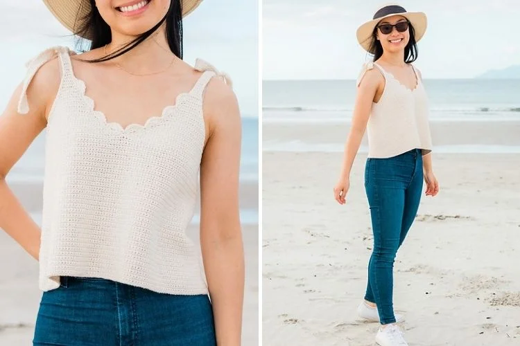 A woman wearing a hat and jeans on the beach.