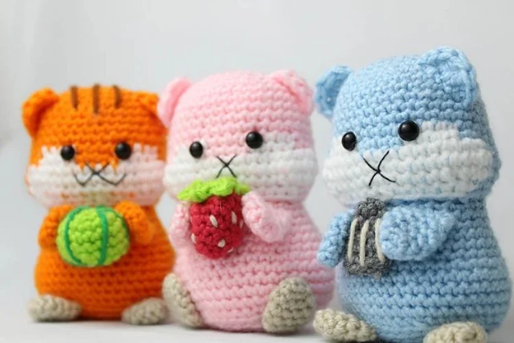 Three crocheted amigurumi animals are sitting next to each other.