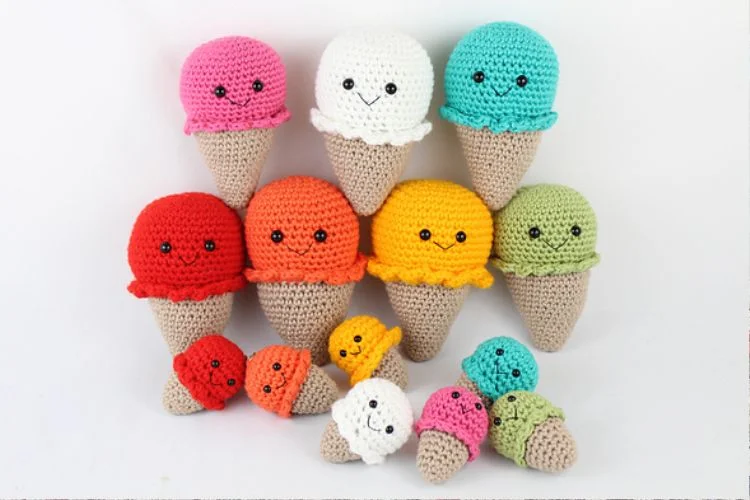 A group of crocheted ice cream cones in different colors.