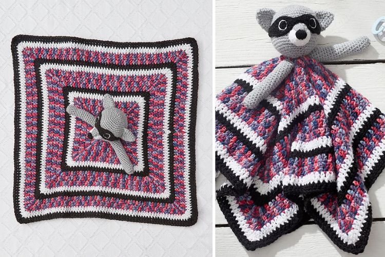 a crochet lovey with a raccoon head and square striped blanket design in prurple, white and black