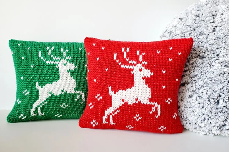 Two crocheted reindeer pillows next to each other.