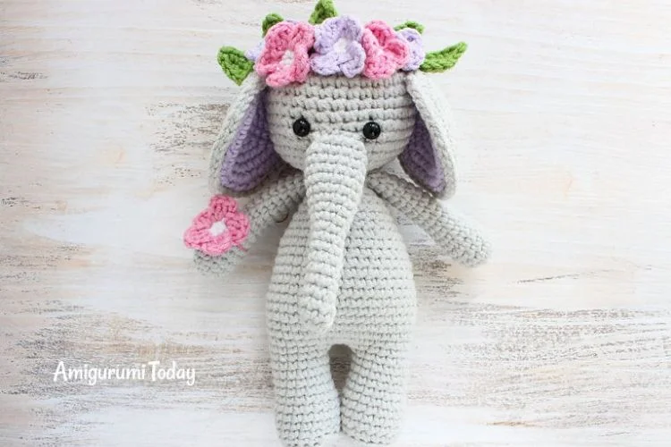 A crocheted elephant wearing a flower crown.