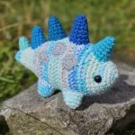 a blue striped crochet stegosaurus amigurumi
