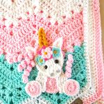 a crochet chevron baby blanket with a unicorn applique