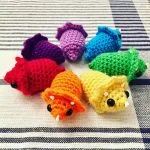 a set of mini crochet triceraptops in rainbow colors