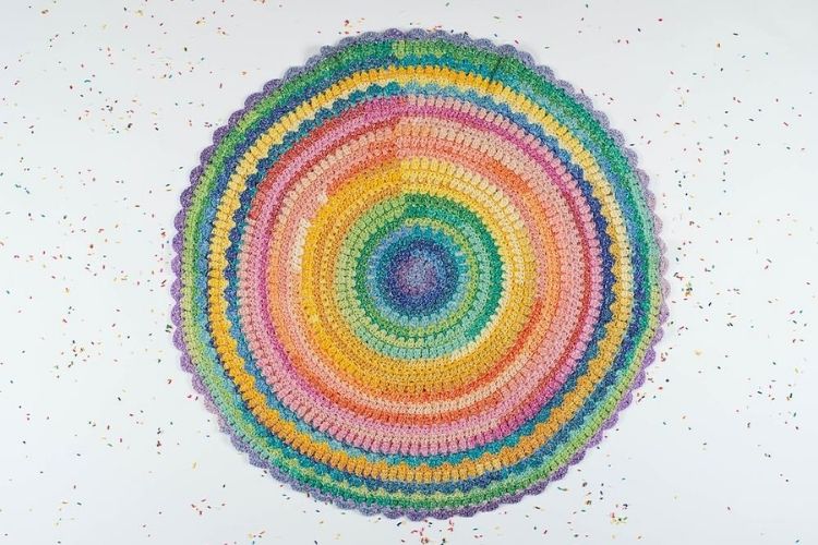 A colorful crocheted circle on a white background.