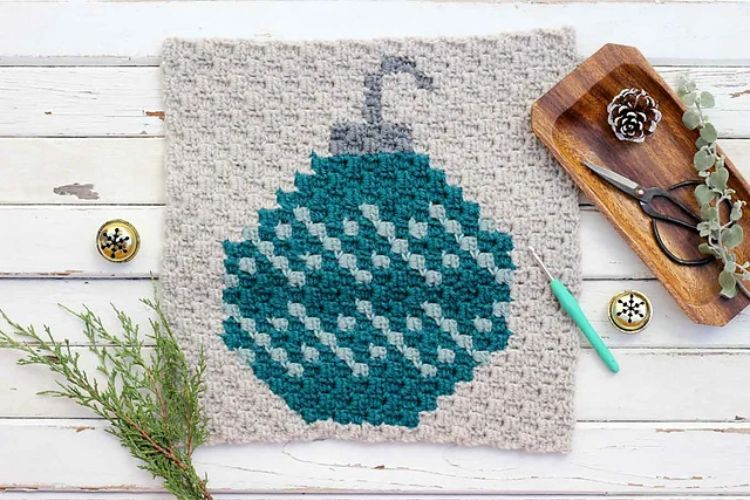 A crocheted christmas ornament on a wooden table.