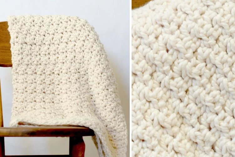 a crochet blanket in a cream color hung on a wooden chair