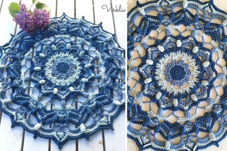 A blue crocheted mandala on a wooden table.