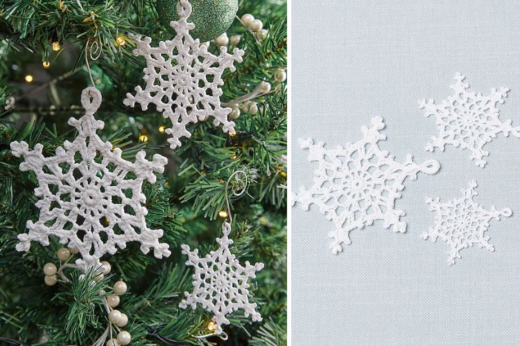 White snowflake ornaments hanging from a christmas tree.