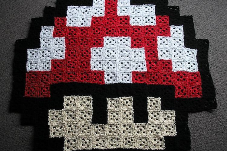 A crocheted mushroom afghan on a table.