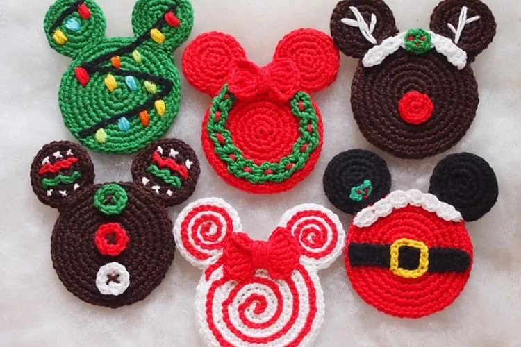 Six mickey mouse crochet ornaments on a white surface.