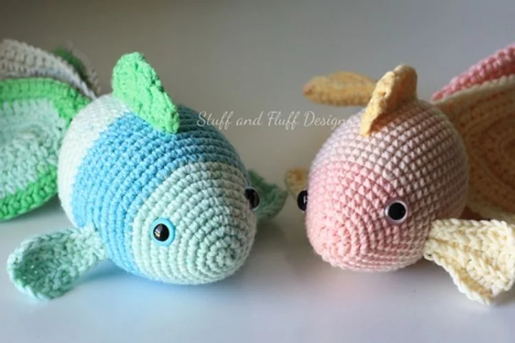 Two crocheted fish sitting next to each other.