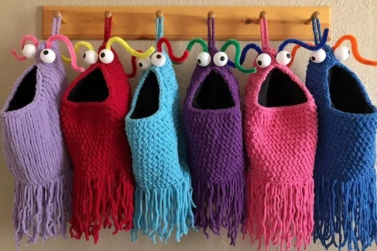 A group of colorful yarn bags hanging on a wall.