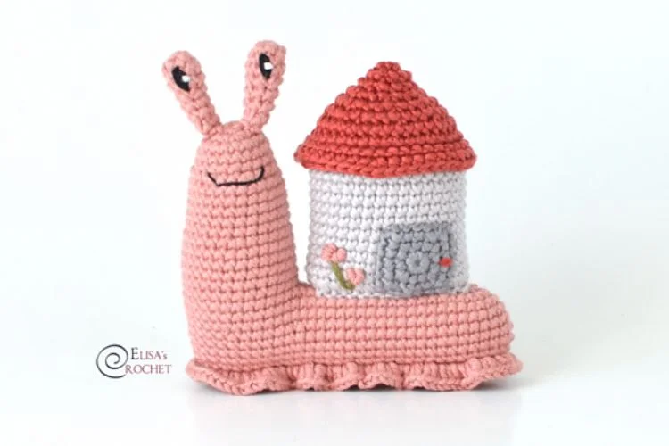 A crocheted snail with a house on it.