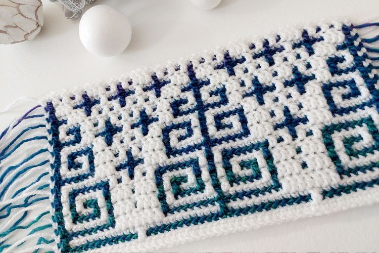 A blue and white crochet pattern on a table.