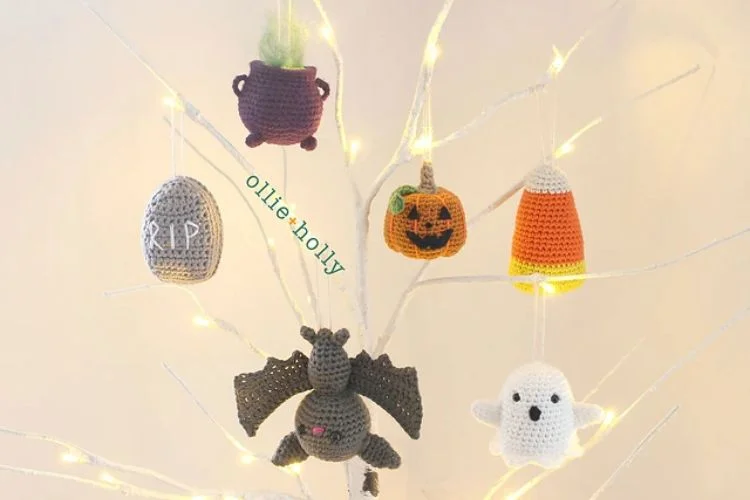 Crocheted halloween ornaments hanging on a tree.