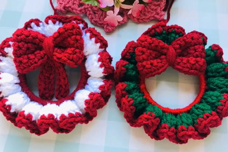 Two Christmas ornaments on a table, intricately crocheted.