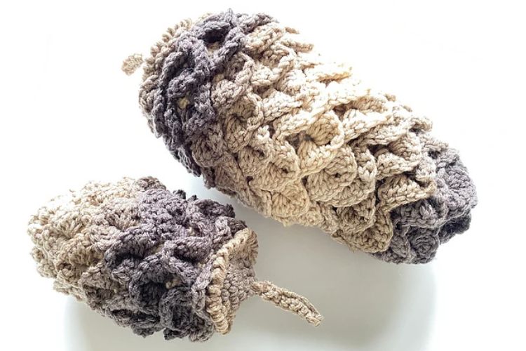 Two crocheted acorns on a white surface.