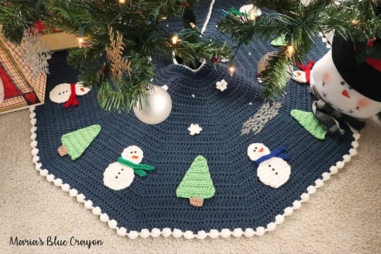 A christmas tree skirt with snowmen on it.