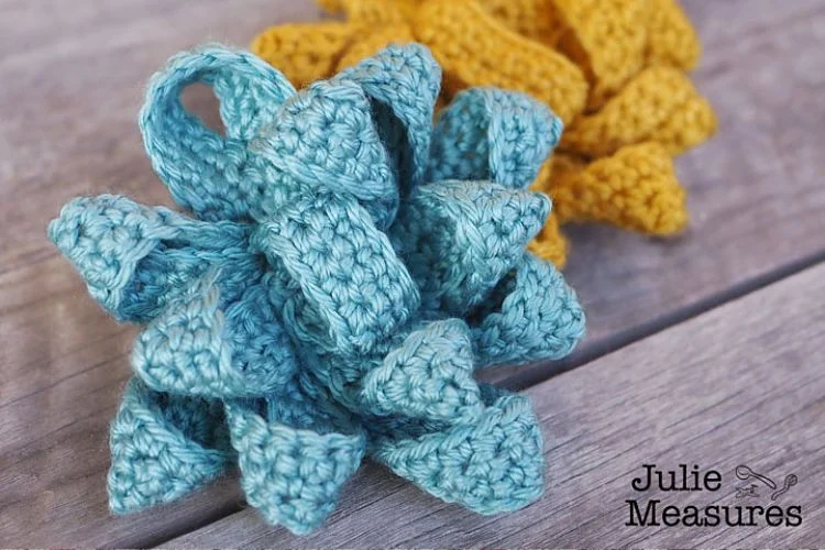 Two crocheted bows on a wooden table.