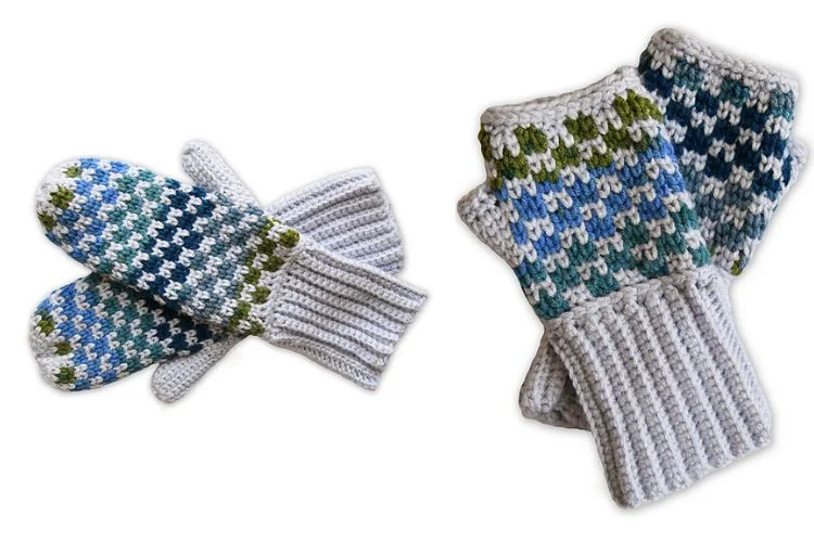 A pair of crocheted mittens with a blue and white pattern.