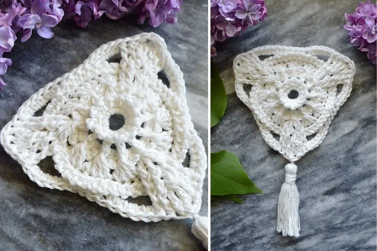 A white crocheted tassel with purple flowers.