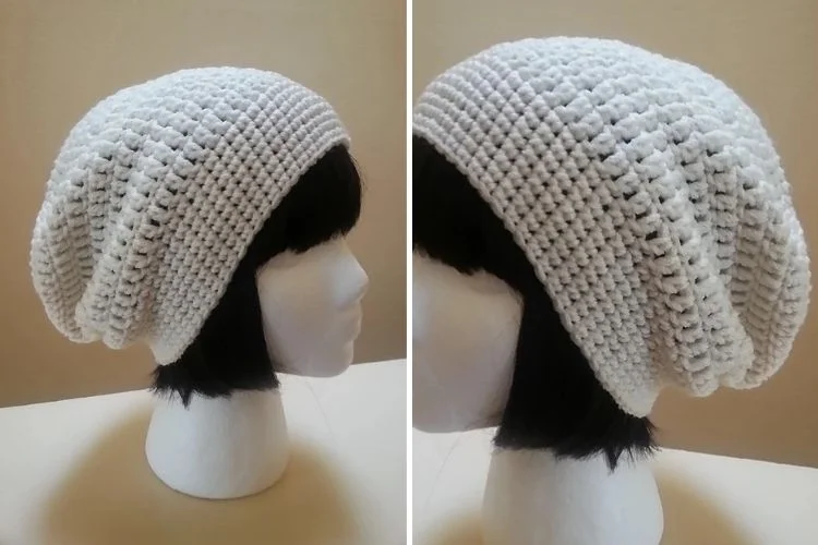 A mannequin wearing a white crocheted slouchy hat.