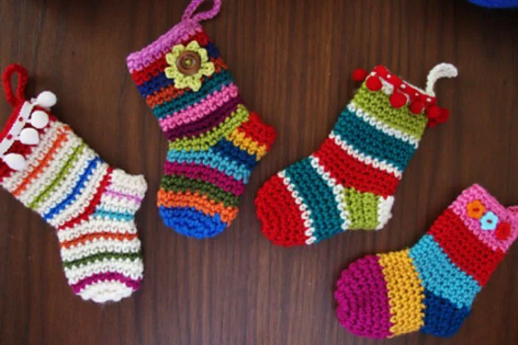 Four crocheted christmas stockings on a wooden table.