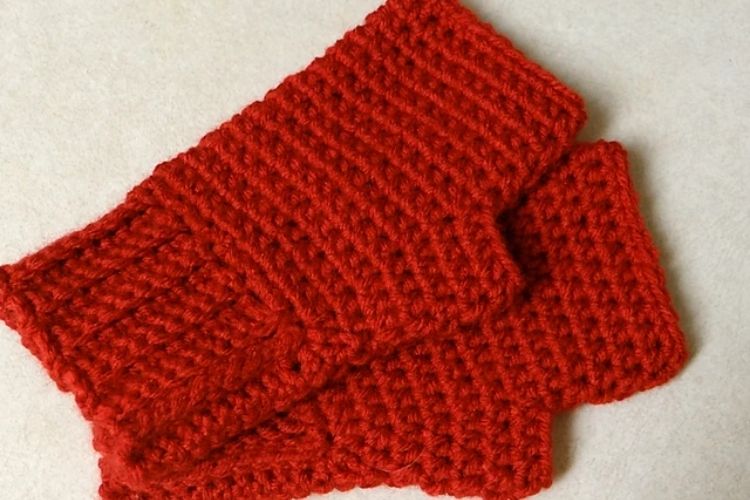 A pair of simple, red fingerless gloves, lovingly crafted with crocheting techniques.