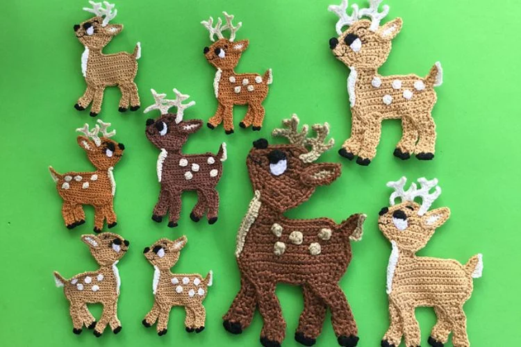 A group of crocheted reindeer appliques on a green background.