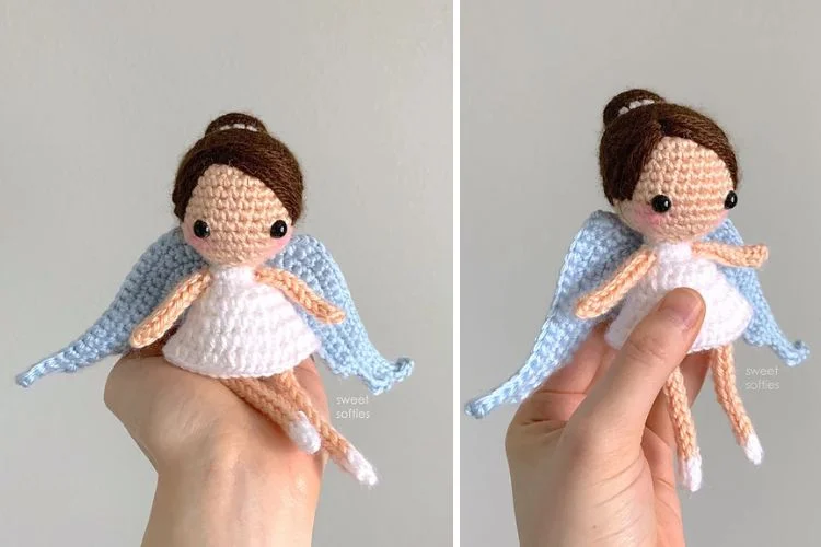 A crocheted amigurumi doll with a blue dress and white wings.