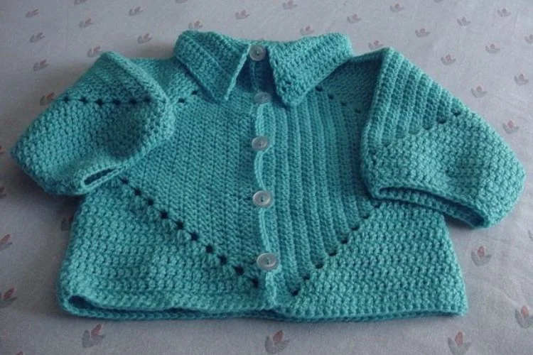 A baby knitted sweater with buttons and a collar.