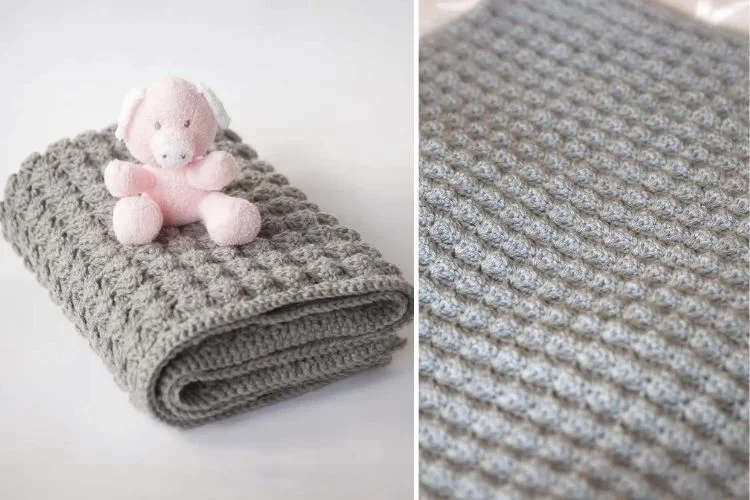 A grey blanket with a pink teddy bear next to it.