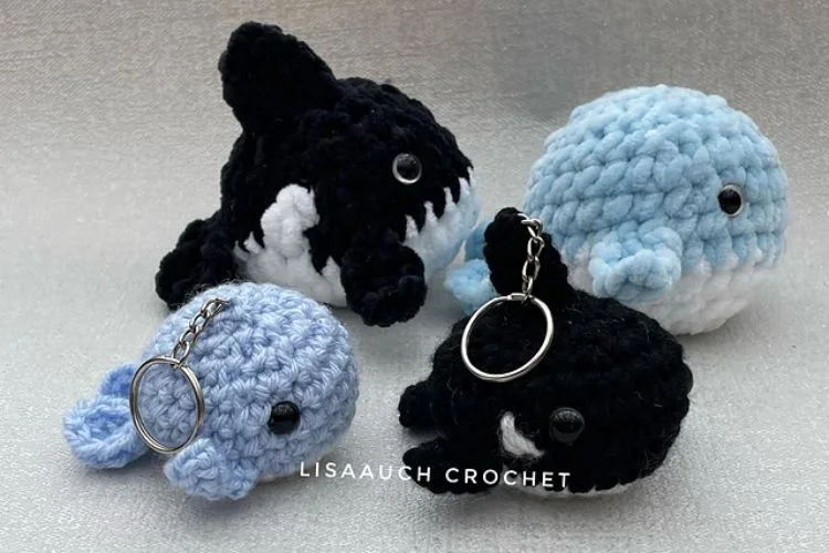 Three crocheted orca whale keychains.