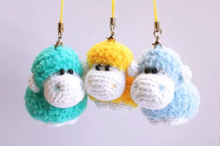 Three crocheted sheep hanging from a string.