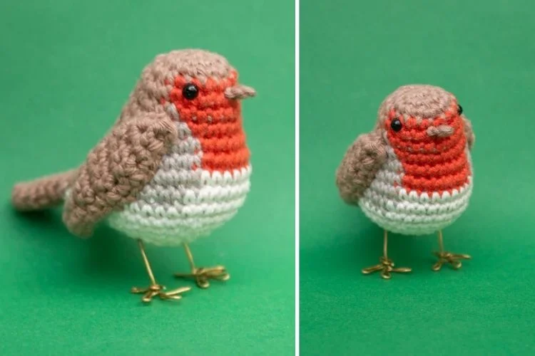 A crocheted robin sitting on a green background.