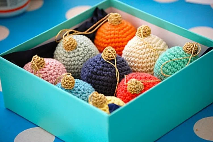 Crocheted christmas ornaments in a blue box.