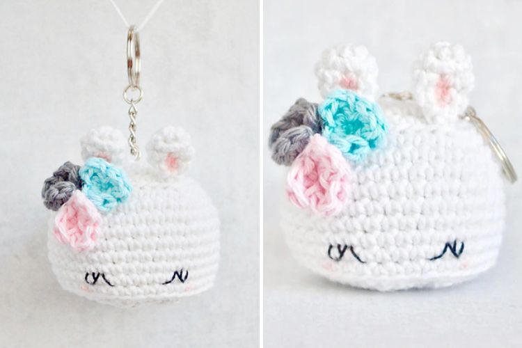 A white crocheted bunny keychain with pink and blue eyes.