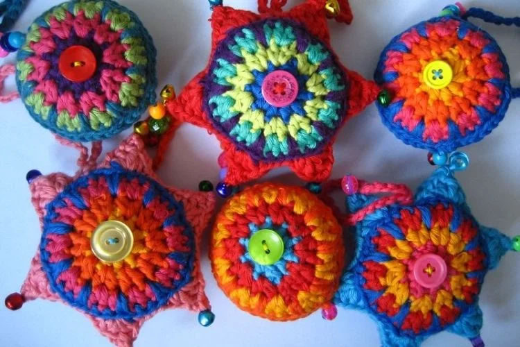 A group of colorful crocheted ornaments with buttons.